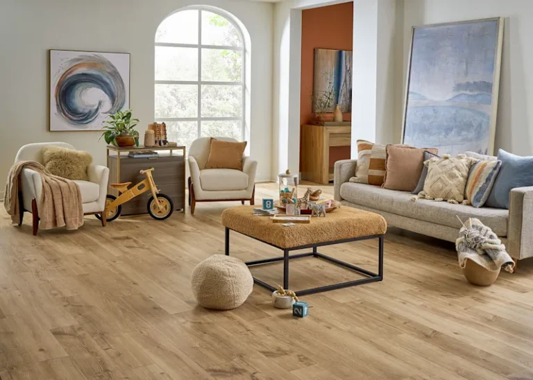 A cozy living room featuring a beige sofa, wooden flooring, and decorative elements like cushions and artwork.